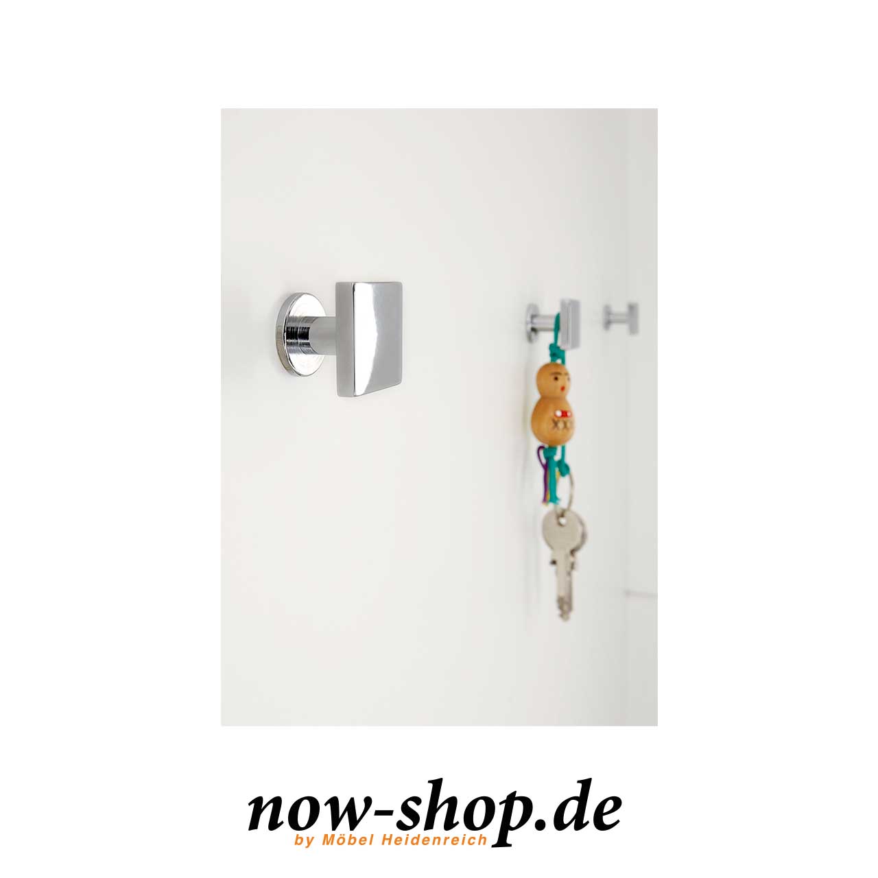 Detailansicht eines Hakens der Garderobe. Detailaufnahme eines Taschenhakens. Dieser ist quadratisch mit abgerundeten Ecken und glänzend.