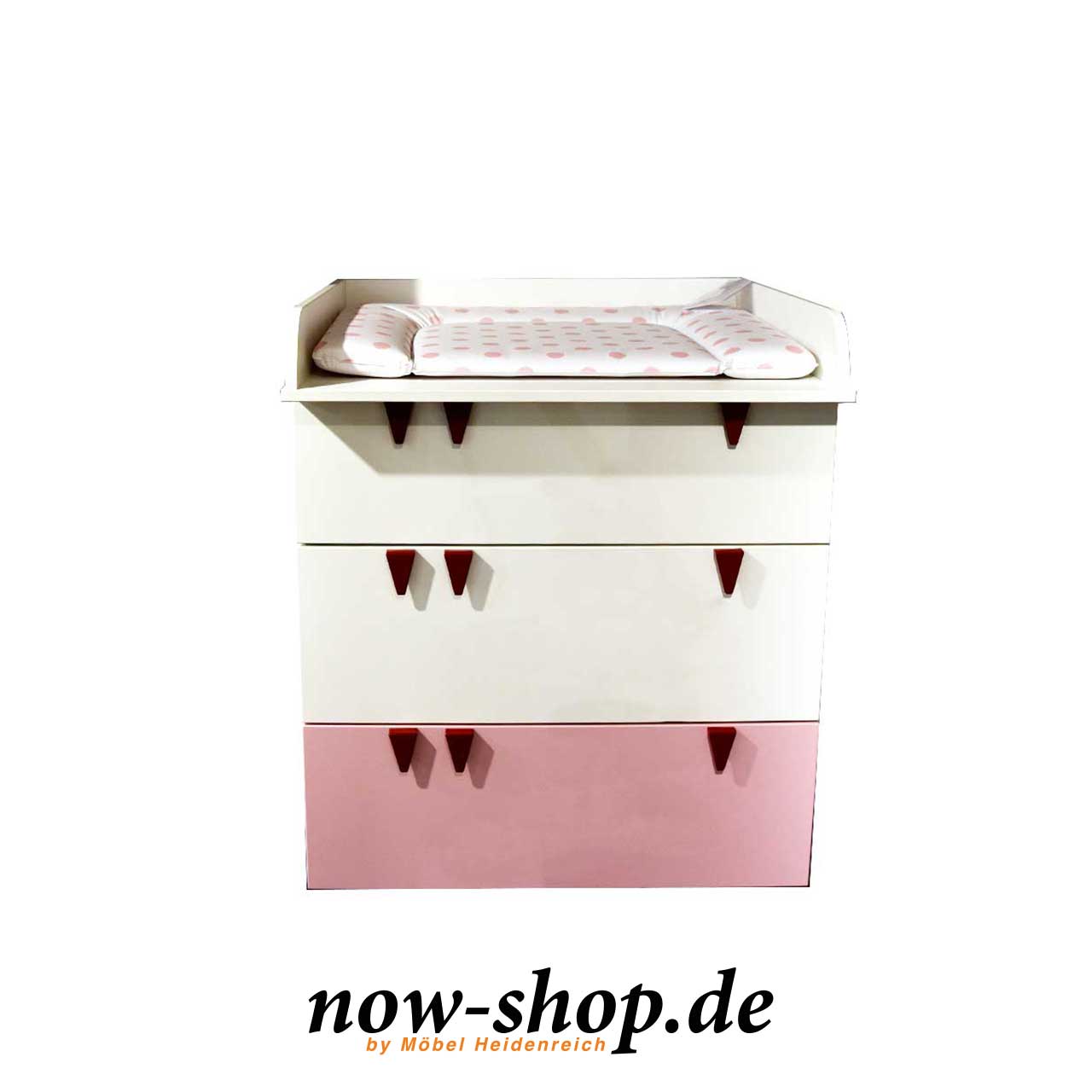 now! by hülsta - minimo Wickelkommode mit Zubehör Ausstellungsstück Weiße Wickelkommode mit drei Schubladen. Die unterste Schublade ist rosa. Alle Schubladen haben je drei rosa Zähnchen als Griffe. Auf der Wickelkommode ist ein weißer Wickelaufsatz montiert. Auf dem Wickelaufsatz liegt eine Wickelauflage mit rosa Punkten.